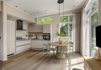 Cocina y comedor modernos con grandes ventanas en la cabaña Heidehof, Forest Park Ede, Países Bajos.