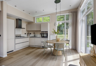 Modernes Küchen- und Esszimmer mit großen Fenstern in der Heidehof-Lodge, Forest Park Ede, Niederlande.