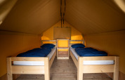Interior of Duo Lodge safari tent with two single beds at Family park Goolderheide in Belgium.