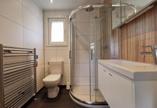 Modern bathroom with shower, toilet, and sink in Comfort cabin at De Woudhoeve in the Netherlands