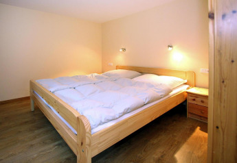 Dormitorio del bungalow «35 qm 2 Pers» en Alemania, con muebles de madera e iluminación cálida.