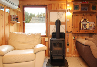 Gezellige woonkamer bij Holiday home «Susanne 58 qm» in Duitsland met houtkachel en zetels.