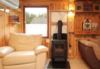Gemütliches Wohnzimmer im Holiday home «Susanne 58 qm» in Deutschland mit Kaminofen und Sesseln.