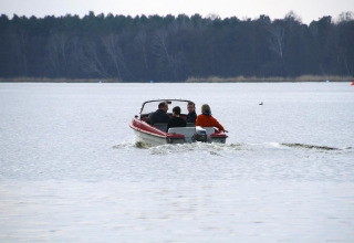 Vier mensen varen op een meer in een motorboot bij Holiday home «Susanne 58 qm» in Duitsland.