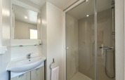 Modernes Badezimmer im Mobile Home „Urederra“ auf dem Campingplatz Etxarri mit Dusche und Waschbecken.