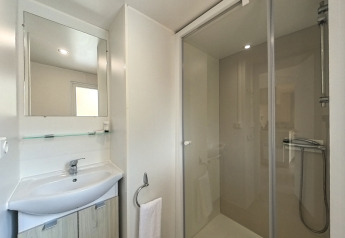 Modernes Badezimmer im Mobile Home „Urederra“ auf dem Campingplatz Etxarri mit Dusche und Waschbecken.