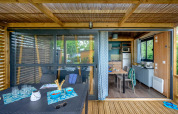 Outdoor terrace and interior view of Cottage «Morea» at Campsite Le Château, France, with dining and kitchen.