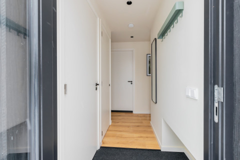 Inkomhal van Forest villa «De Bosburcht» met licht houten vloer, witte deuren en minimalistisch design.