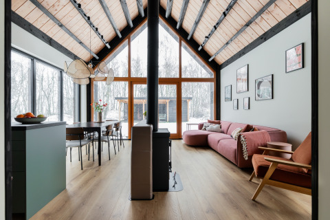 Moderne bosvilla met hoog plafond, grote ramen, houten interieur en sneeuwzicht bij De Kremmer, Nederland.