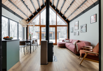 Modernes Ferienhaus mit hohen Decken, großen Fenstern und Waldblick im verschneiten De Kremmer, Niederlande.