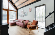 Lys og moderne stue i Forest villa «De Bosburcht» med store vinduer og udsigt til et snedækket landskab.