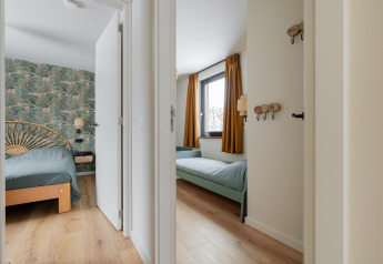 Eingang zu zwei Schlafzimmern in der Forest villa «De Bosburcht» mit Waldtapete und Holzboden.