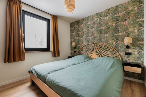 Slaapkamer in Forest villa «De Bosburcht» te De Kremmer, Nederland, met bosbehang en groen beddengoed.