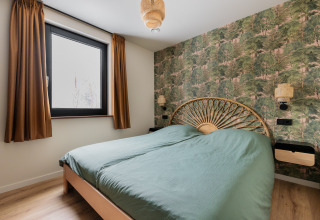 Camera da letto presso Forest villa «De Bosburcht» a De Kremmer, Paesi Bassi, con carta da parati bosco.