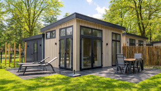 Lodge Veldzicht luminoso con terraza moderna, tumbonas y comedor exterior rodeado de árboles verdes.