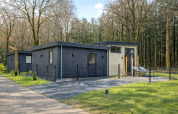 Lodge moderno llamado Veldzicht en Forest Park Ede, Países Bajos, rodeado de árboles y naturaleza.