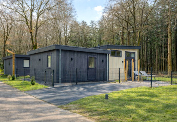 Moderne lodge Veldzicht in Forest Park Ede, Nederland, omringd door bomen en groene natuur.