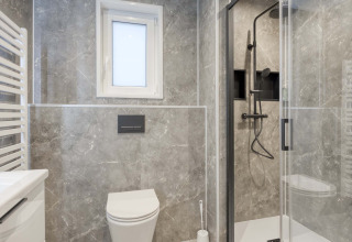 Moderne badkamer met marmeren tegels, douche, toilet en raam in Veldzicht, Forest Park Ede.