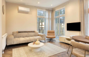 Woonkamer in lodge Veldzicht in Forest Park Ede, Nederland, met modern interieur, bank en grote ramen.