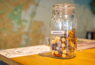 Ein Glasgefäß mit der Aufschrift 'HONDENKOEKJES' voller Hundekekse im Ferienpark Gooise Heide, Nordholland.