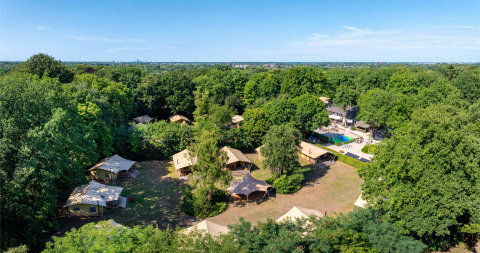 Vue aérienne du parc de vacances Gooise Heide en Hollande-Septentrionale, entouré d’arbres et de tentes.