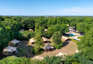 Vista aérea del parque vacacional Gooise Heide en Holanda Septentrional, rodeado de árboles y tiendas de campaña.