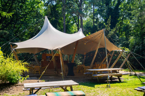 Grande tente extérieure avec tables et chaises, dans le parc de vacances Gooise Heide, en Hollande-Septentrionale.