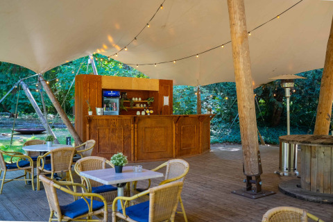 Cafetería al aire libre con mesas de madera, barra y toldo en Gooise Heide, parque vacacional en Países Bajos.