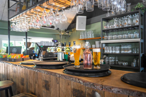 Bar en el parque vacacional Gooise Heide en Holanda Septentrional con vasos, cerveza y botellas.