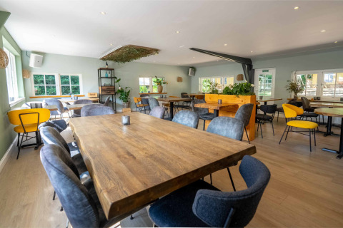 Zona de comedor luminosa y espaciosa en el parque vacacional Gooise Heide en Holanda Septentrional, Países Bajos.