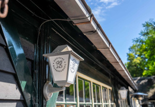 Udendørs væglampe med logoet 'Gooische Bierbrouwerij', set på en bygning i ferieparken Gooise Heide.