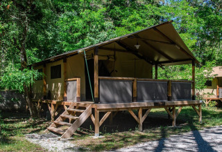 Hytte-telt på Flower Camping la Pinède, omgivet af grønne træer i Auvergne-Rhône-Alpes, Frankrig.