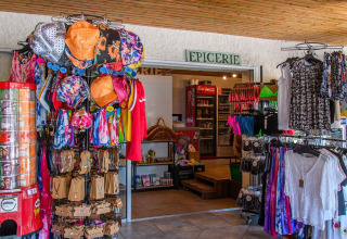 Indgang til campingpladsens butik med tøj, souvenirs og automater på Flower Camping la Pinède i Frankrig.