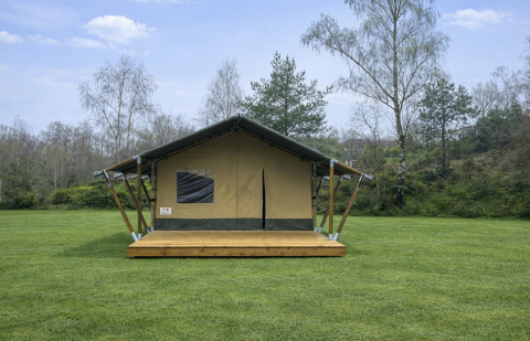 Safaritent genaamd Glamfield Lodge II bij Wilsumer Berge in Duitsland, op een groen grasveld.