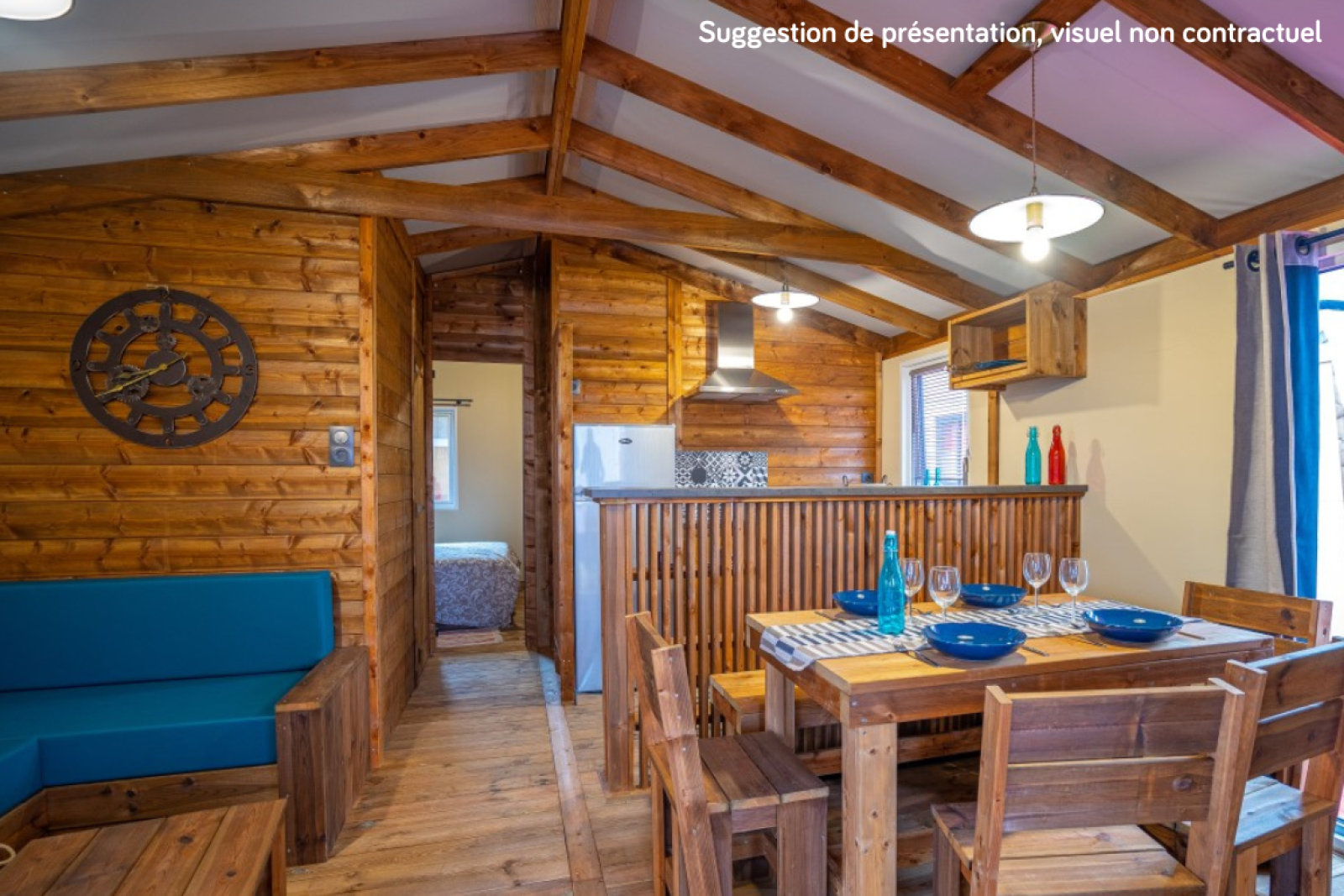 Knus houten lodge-interieur met eet- en keukengedeelte bij Lodge Premium VIP, Flower Camping L'Ile d'Offard.