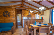 Gemütliches Holz-Lodge-Interieur mit Essbereich und Küche im Lodge Premium VIP, Flower Camping L'Ile d'Offard.