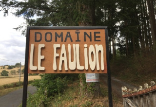 Cartello di Domaine Le Faulion, un villaggio vacanze in Bourgogne-Franche-Comté, Francia, accanto a una foresta.