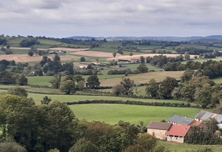 Paesaggio rurale vicino a Cuzy, Borgogna-Franca Contea, Francia, con campi, alberi e case rurali.
