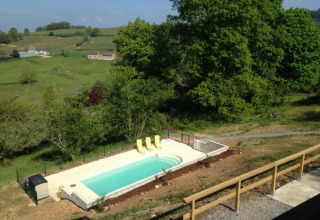 Uitzicht op het zwembad met ligstoelen bij Domaine Le Faulion, vakantiepark in Bourgogne-Franche-Comté, Frankrijk.