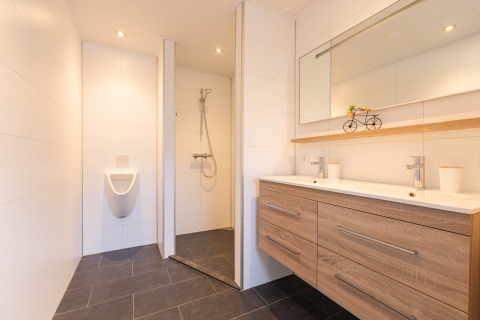 Bagno moderno nella Villa BushBush a De Kremmer, Paesi Bassi, con doppio lavabo, doccia e orinatoio.