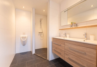 Bagno moderno nella Villa BushBush a De Kremmer, Paesi Bassi, con doppio lavabo, doccia e orinatoio.