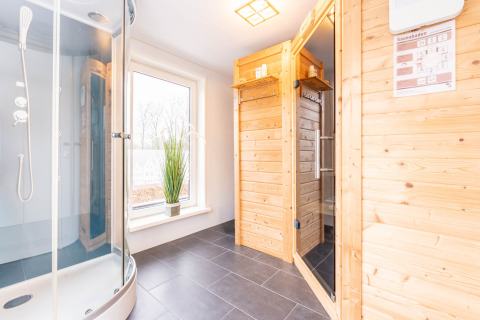 Bagno moderno e sauna in legno con doccia presso Villa «BushBush», De Kremmer, Paesi Bassi, vista luminosa.