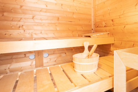 Interno di sauna in legno chiaro con panche e secchio, fotografato a Villa «BushBush» a De Kremmer, Paesi Bassi.