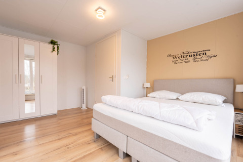 Camera luminosa e moderna alla Villa «BushBush» a De Kremmer, Paesi Bassi, con letto matrimoniale e armadio.