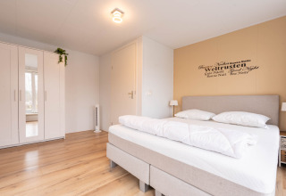 Camera luminosa e moderna alla Villa «BushBush» a De Kremmer, Paesi Bassi, con letto matrimoniale e armadio.
