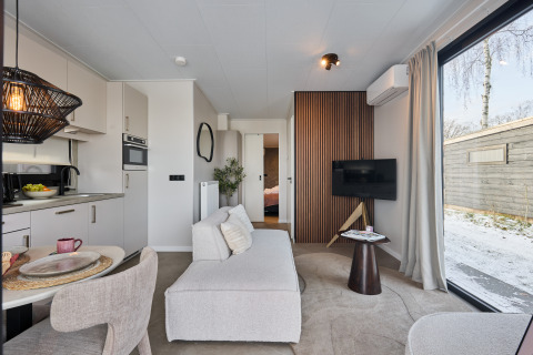 Zona giorno moderna nella Happy Oak wellnesslodge al Holiday park Mölke, Paesi Bassi, con cucina a vista.