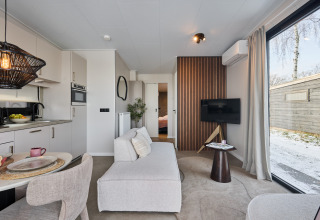 Modernes Wohnzimmer in der Happy Oak Wellnesslodge im Holiday Park Mölke, Niederlande, mit offener Küche.