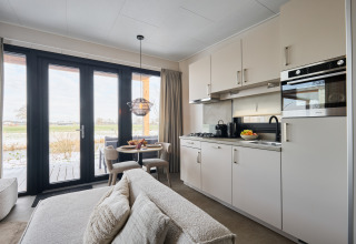Cucina moderna e zona pranzo nella Happy Oak wellnesslodge all'Holiday park Mölke nei Paesi Bassi.