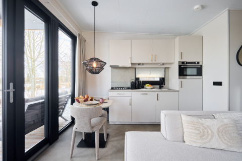 Cucina moderna e zona pranzo nella Happy Oak wellnesslodge al Holiday park Mölke nei Paesi Bassi.