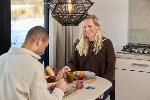 Two people enjoy breakfast together at Happy Oak wellnesslodge, Holiday park Mölke in the Netherlands.